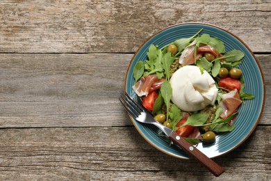 Photo of Delicious burrata salad served on wooden table, top view. Space for text