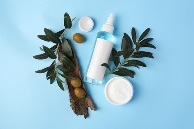 Flat lay composition with different cosmetic products and olives on light blue background