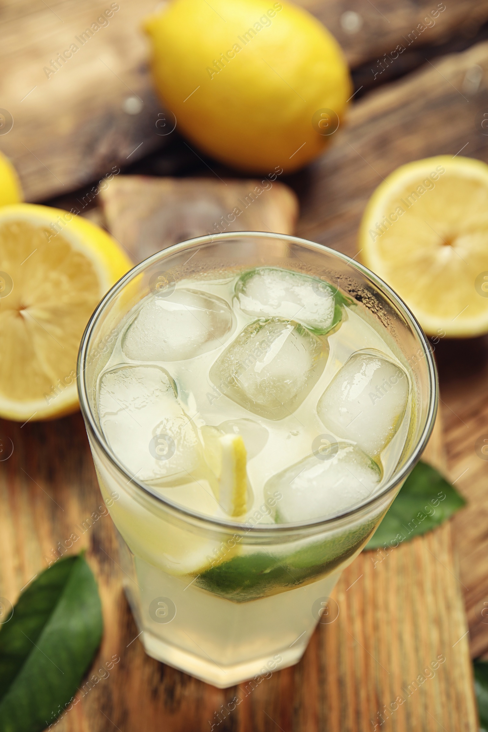 Photo of Cool freshly made lemonade in glass on wooden table, closeup