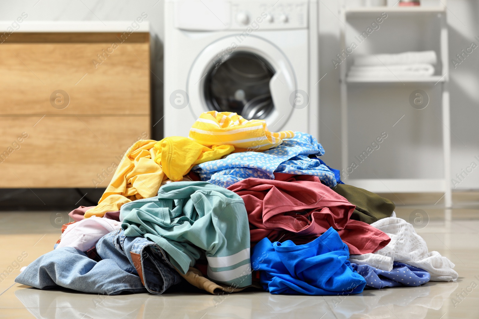 Photo of Pile of dirty clothes on floor in laundry room