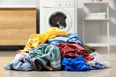 Photo of Pile of dirty clothes on floor in laundry room