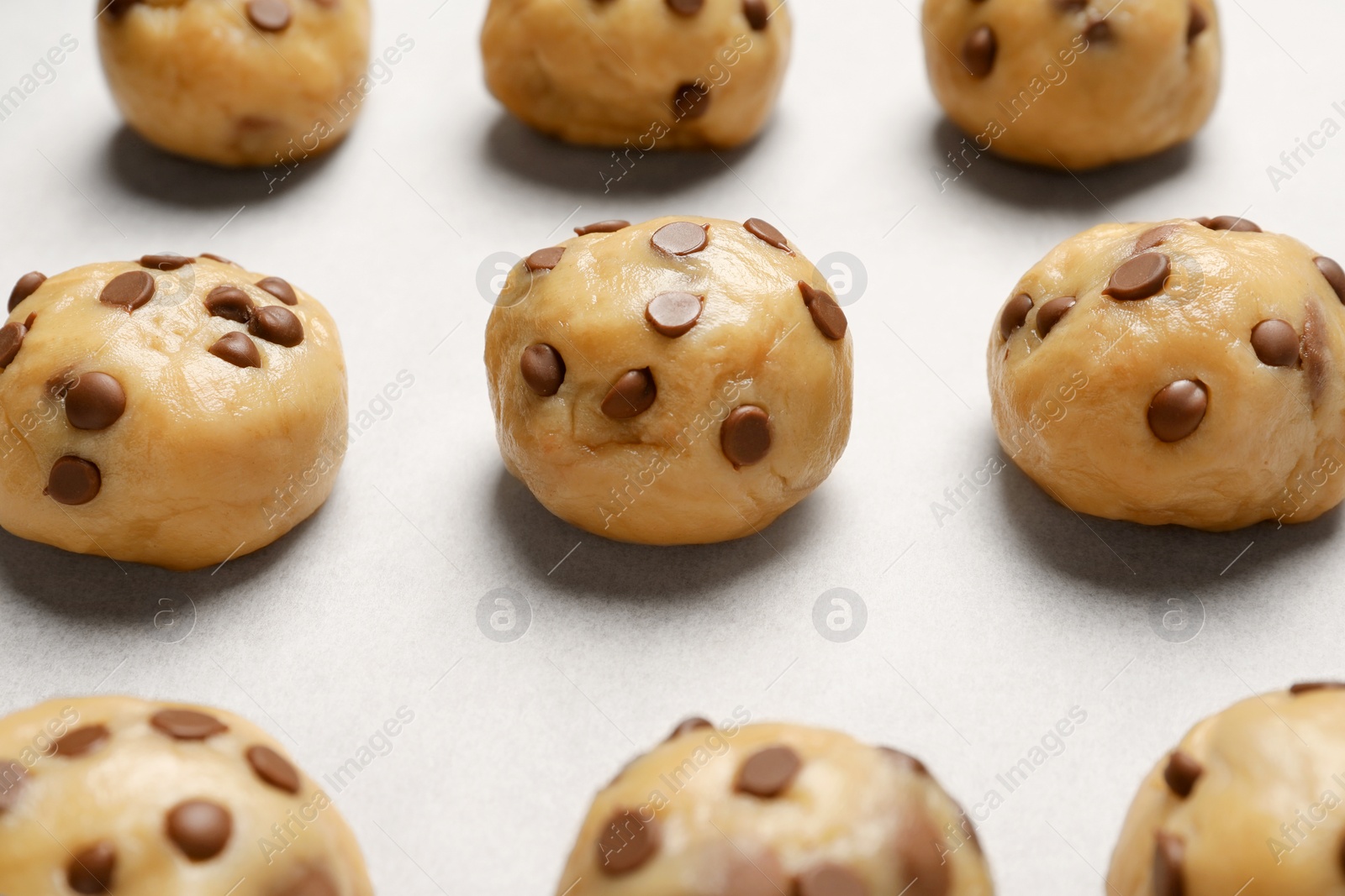 Photo of Uncooked chocolate chip cookies on table, closeup