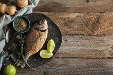 Delicious dorado fish served on wooden table, flat lay. Space for text