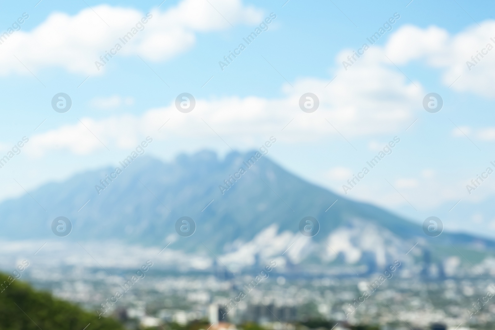 Photo of Blurred view of city with mountains under beautiful sky