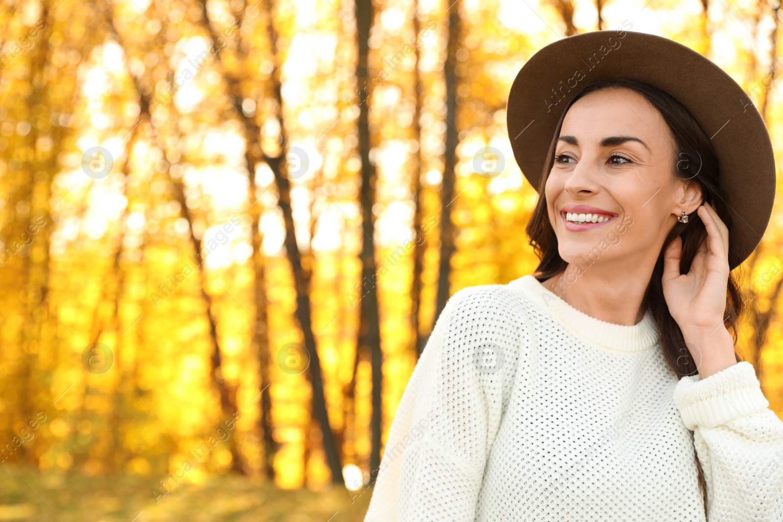 Photo of Beautiful happy woman wearing hat in park. Autumn walk