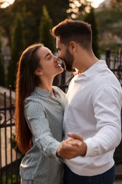 Photo of Lovely couple dancing together outdoors at sunset