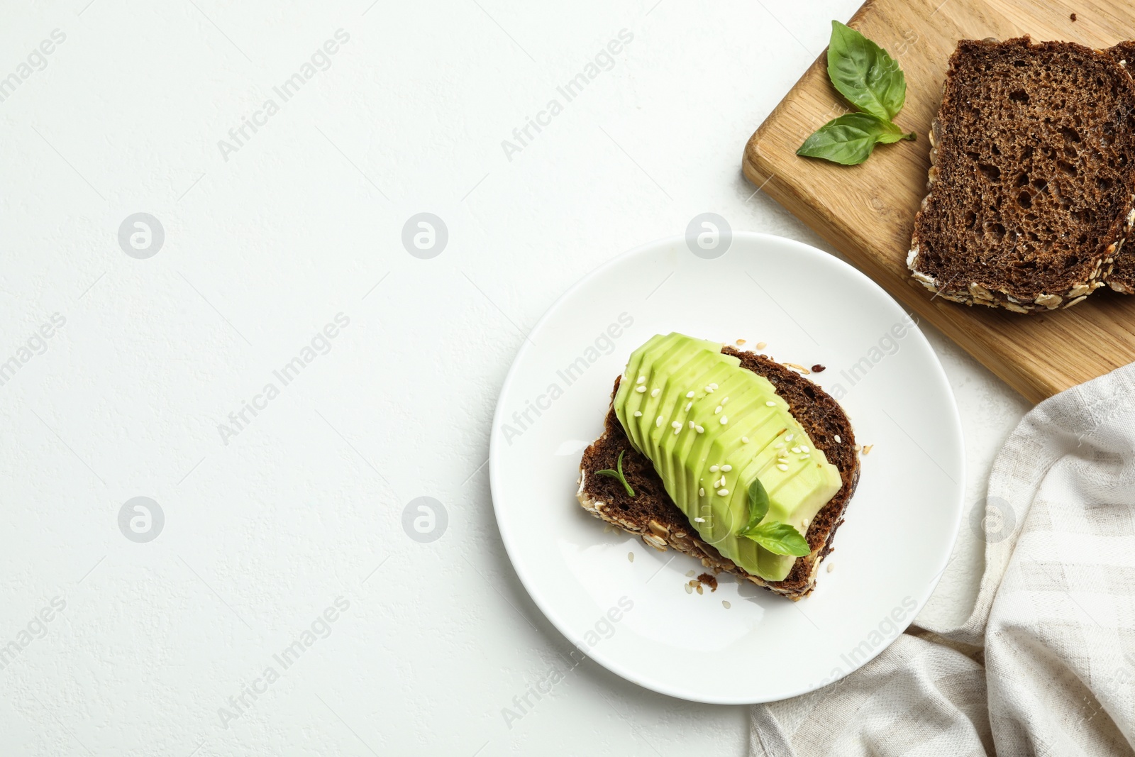 Photo of Flat lay composition with avocado sandwich on white table. Space for text