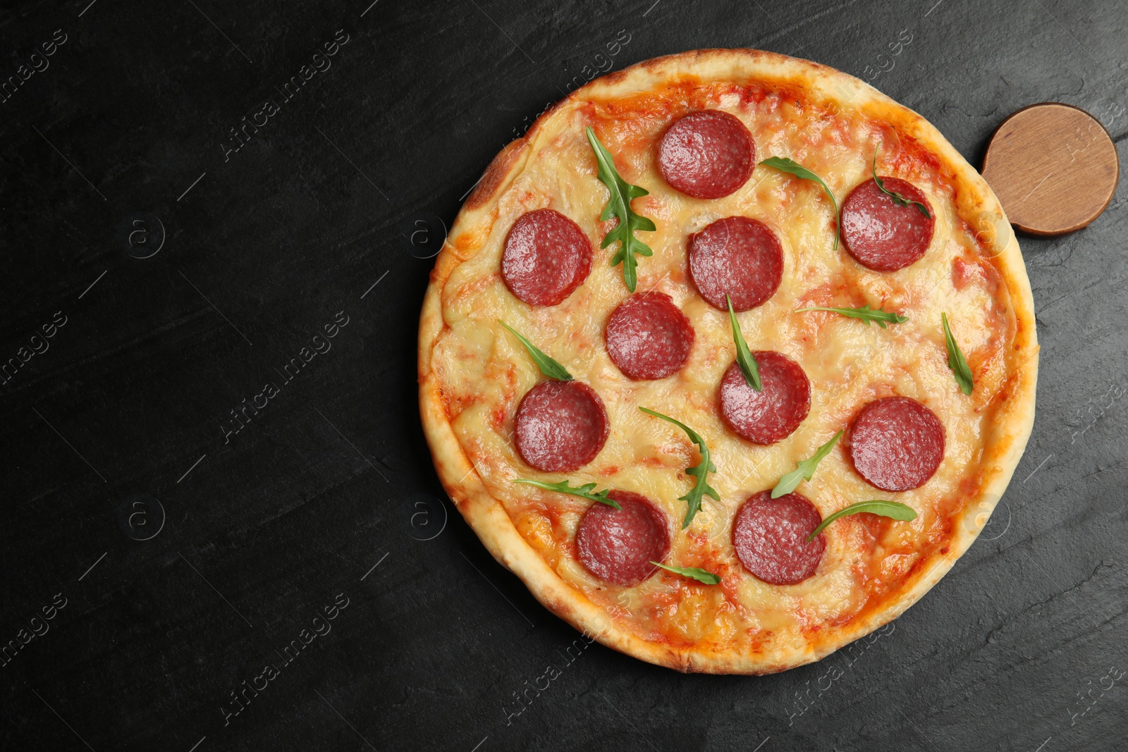 Photo of Tasty pepperoni pizza on black table, top view