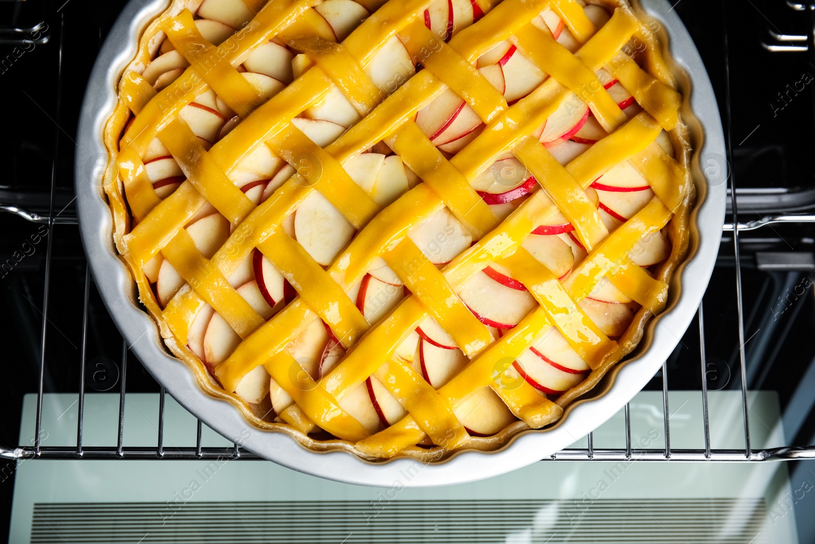 Photo of Traditional English apple pie on shelf of oven, top view