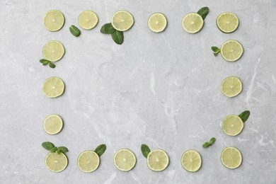 Photo of Flat lay composition with slices of fresh juicy limes on marble table. Space for text