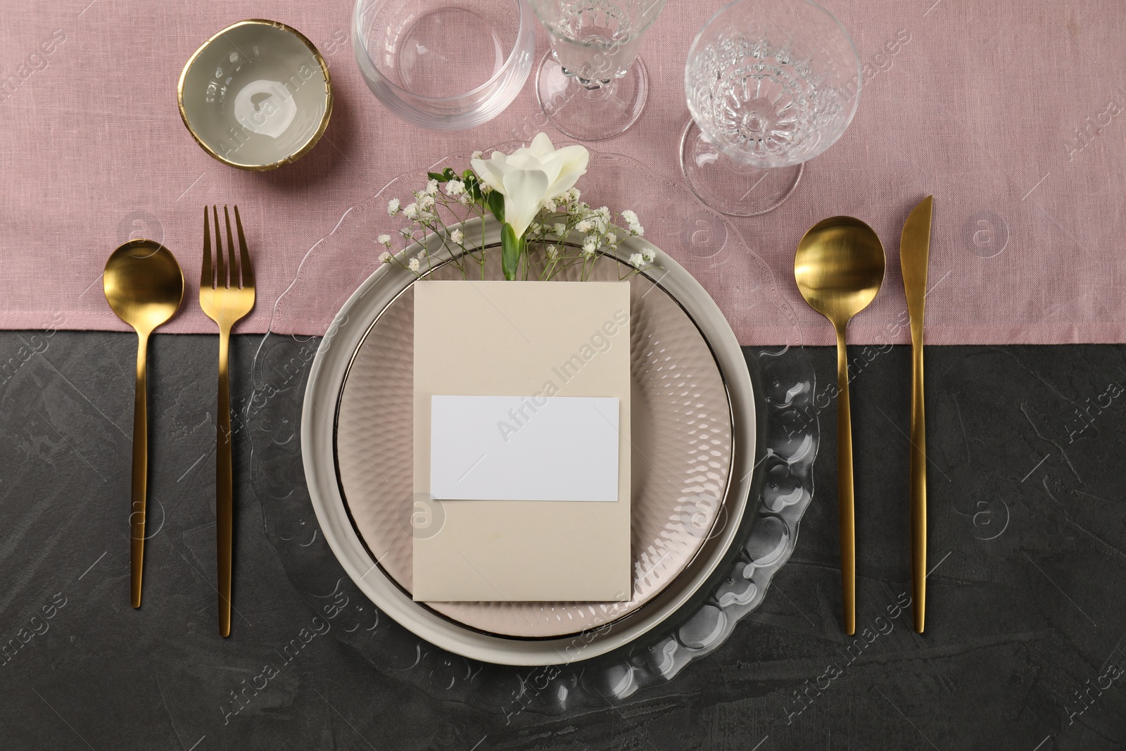 Photo of Stylish table setting. Dishes, cutlery, blank card and floral decor, flat lay