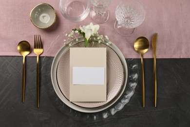 Stylish table setting. Dishes, cutlery, blank card and floral decor, flat lay