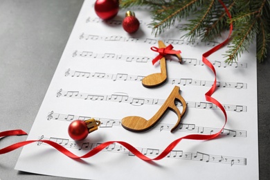 Photo of Christmas decorations, notes and music sheet on grey stone table