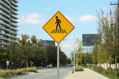 Photo of Post with road sign Pedestrian Crossing on city street
