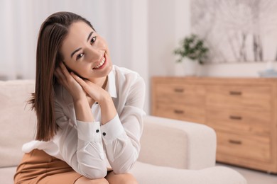 Portrait of beautiful woman smiling in room, space for text