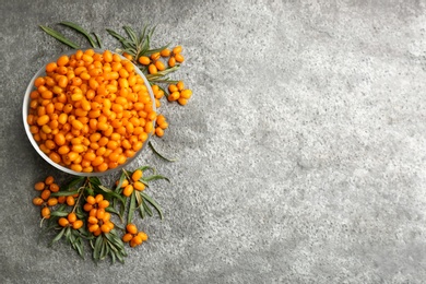 Fresh ripe sea buckthorn on grey table, flat lay. Space for text