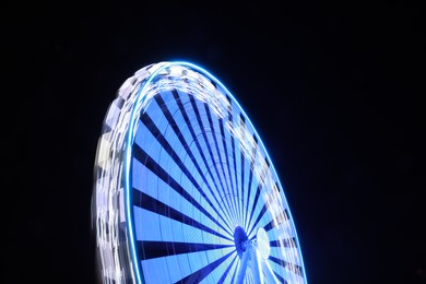 Photo of Beautiful glowing Ferris wheel against dark sky