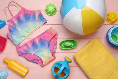 Photo of Flat lay composition with beach ball and sand toys on pink wooden background