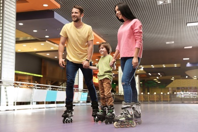 Happy family spending time at roller skating rink