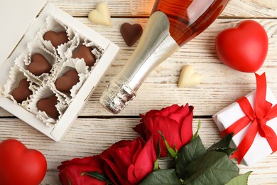 Photo of Flat lay composition with heart shaped chocolate candies on white wooden table. Valentine's day celebration
