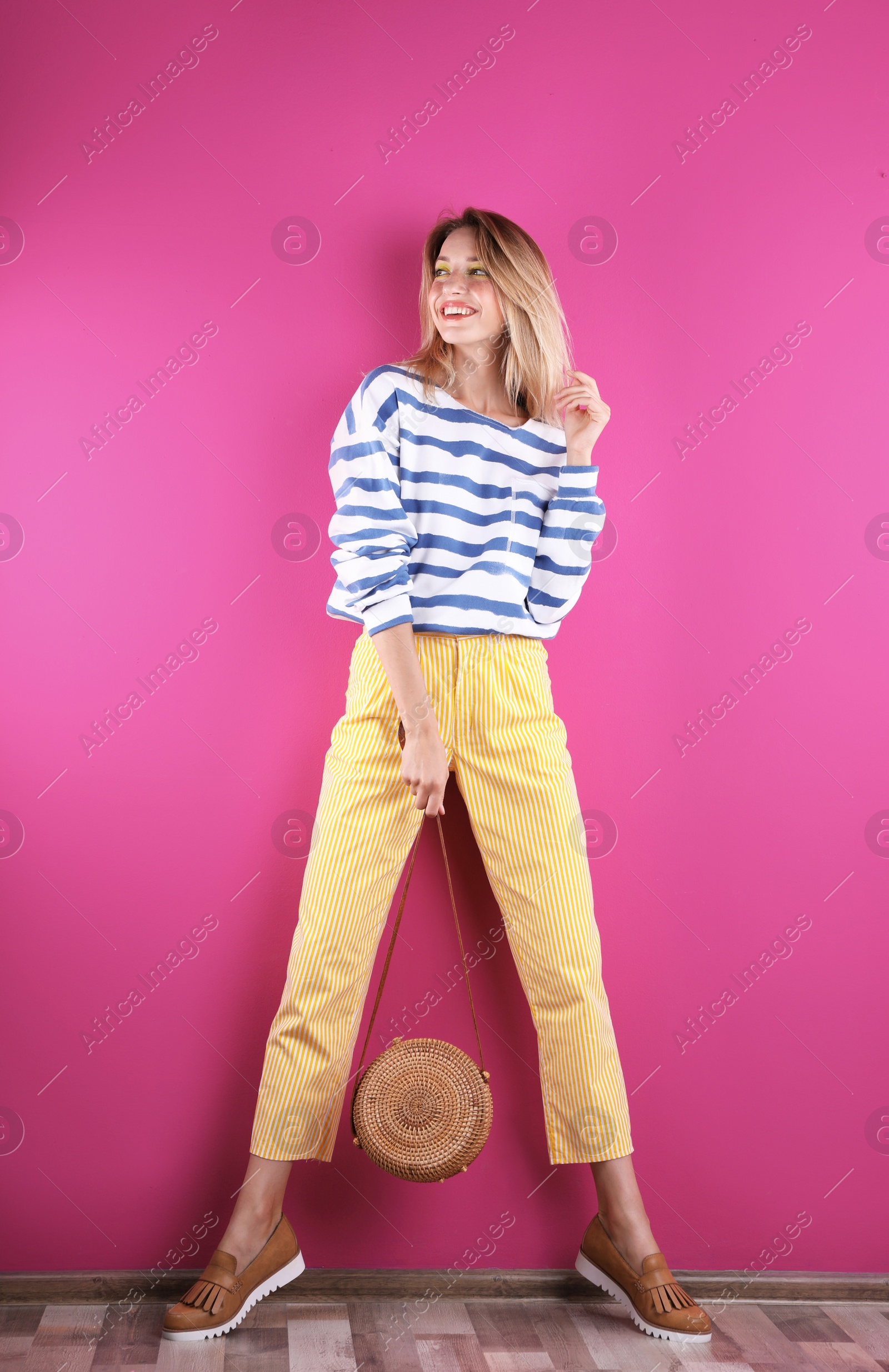 Photo of Beautiful young woman posing near color wall. Summer fashion