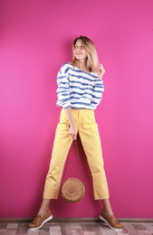 Photo of Beautiful young woman posing near color wall. Summer fashion