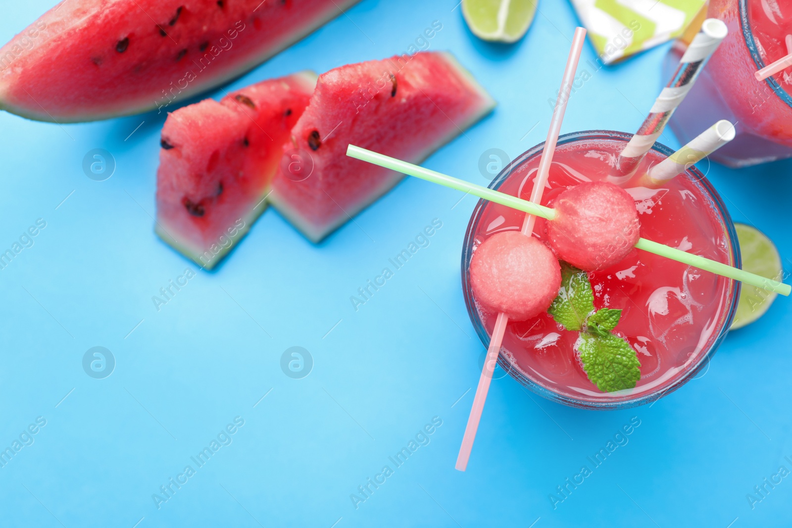 Photo of Tasty watermelon drink on light blue background, flat lay. Space for text