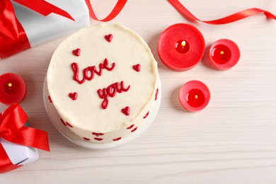 Photo of Bento cake with text Love You, candles, gift boxes and space for text on white wooden table, flat lay. St. Valentine's day surprise