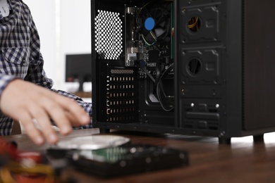 Male technician repairing computer at table, closeup