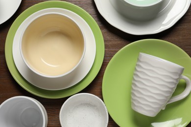 Photo of Beautiful ceramic dishware and cup on wooden table, flat lay