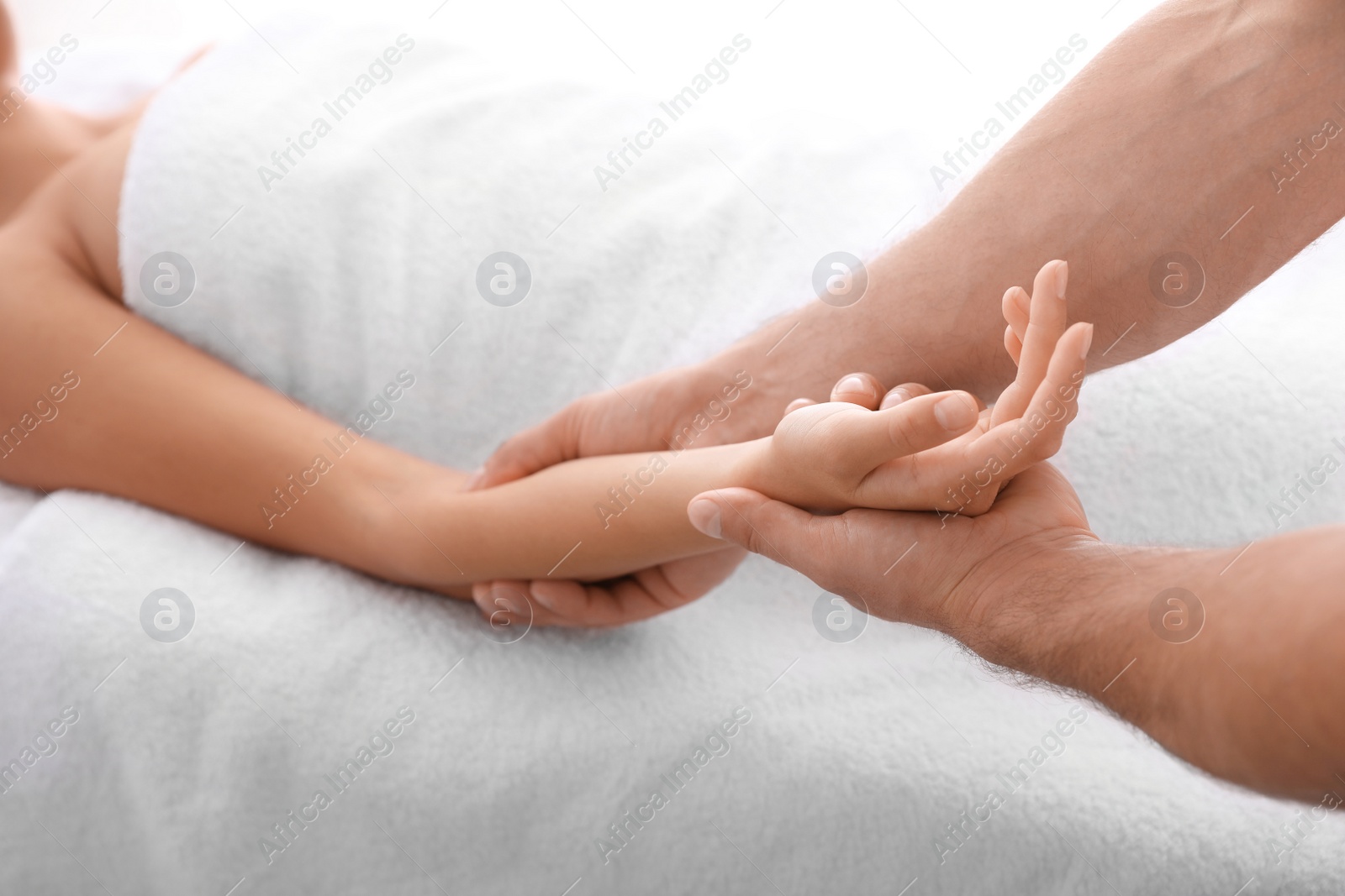 Photo of Young woman receiving massage in salon, closeup