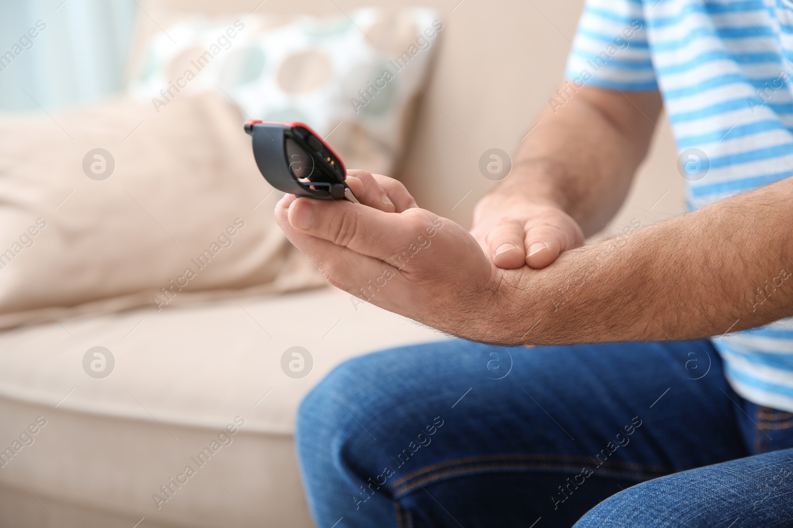 Photo of Mature man checking pulse with fingers at home, closeup