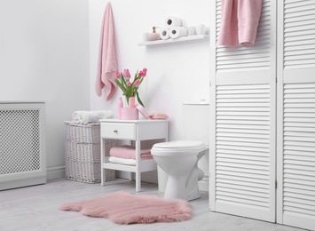 Interior of stylish bathroom with toilet bowl and decor elements