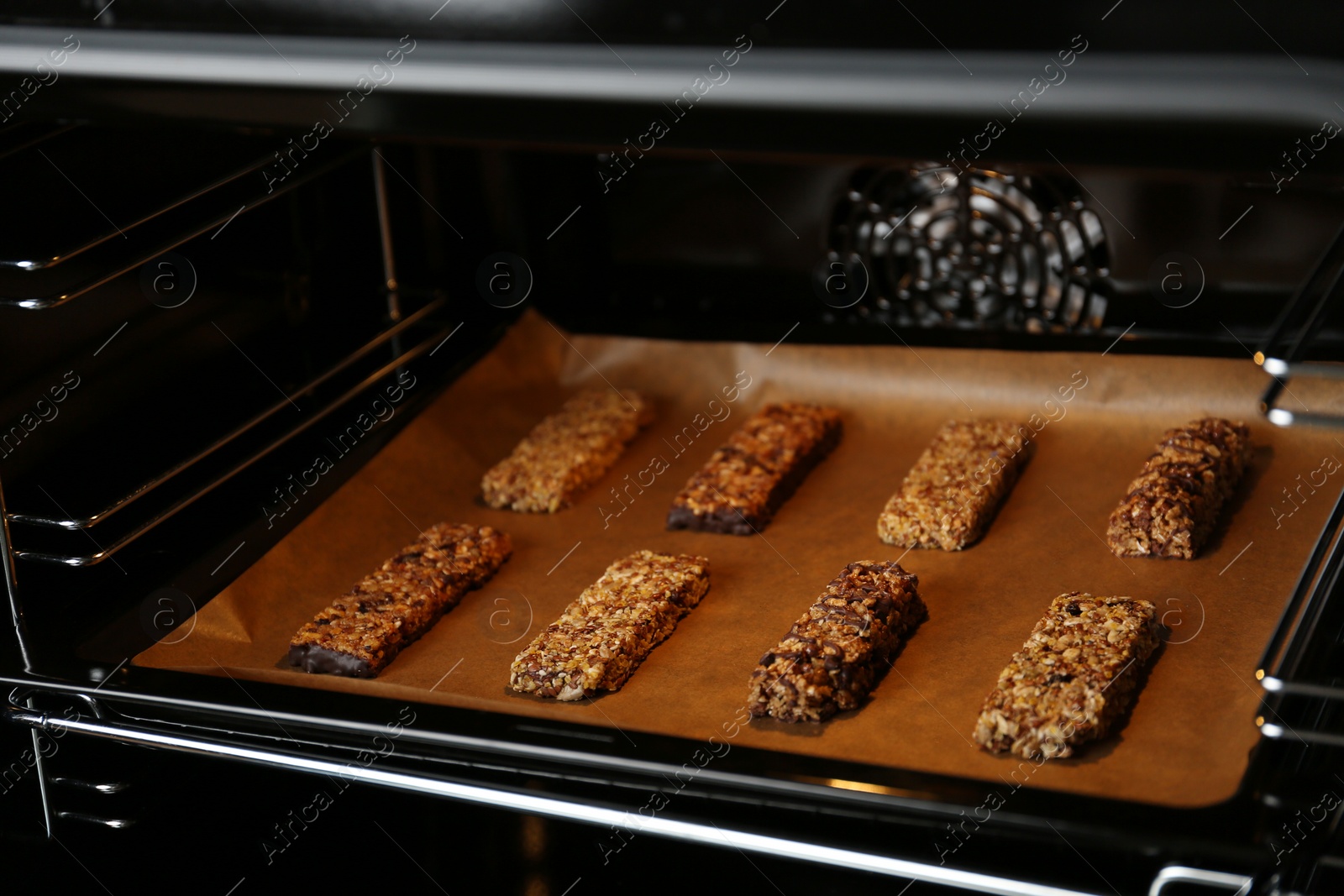 Photo of Delicious healthy granola bars on baking sheet in oven