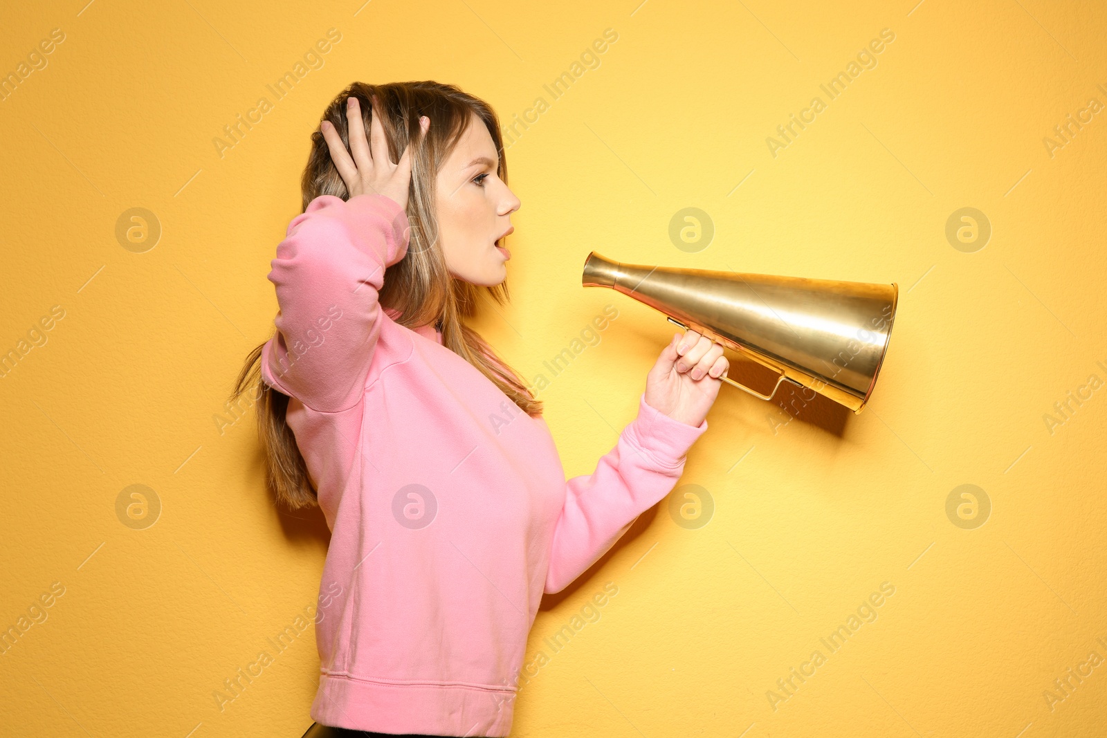 Photo of Young woman with megaphone on color background