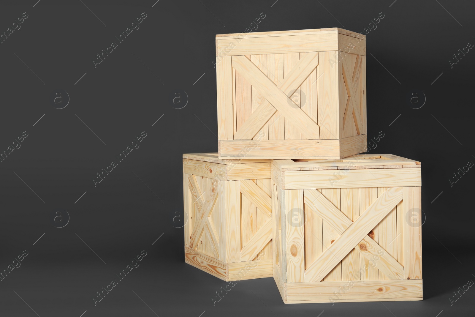 Photo of Wooden crates on dark background, space for text. Shipping containers