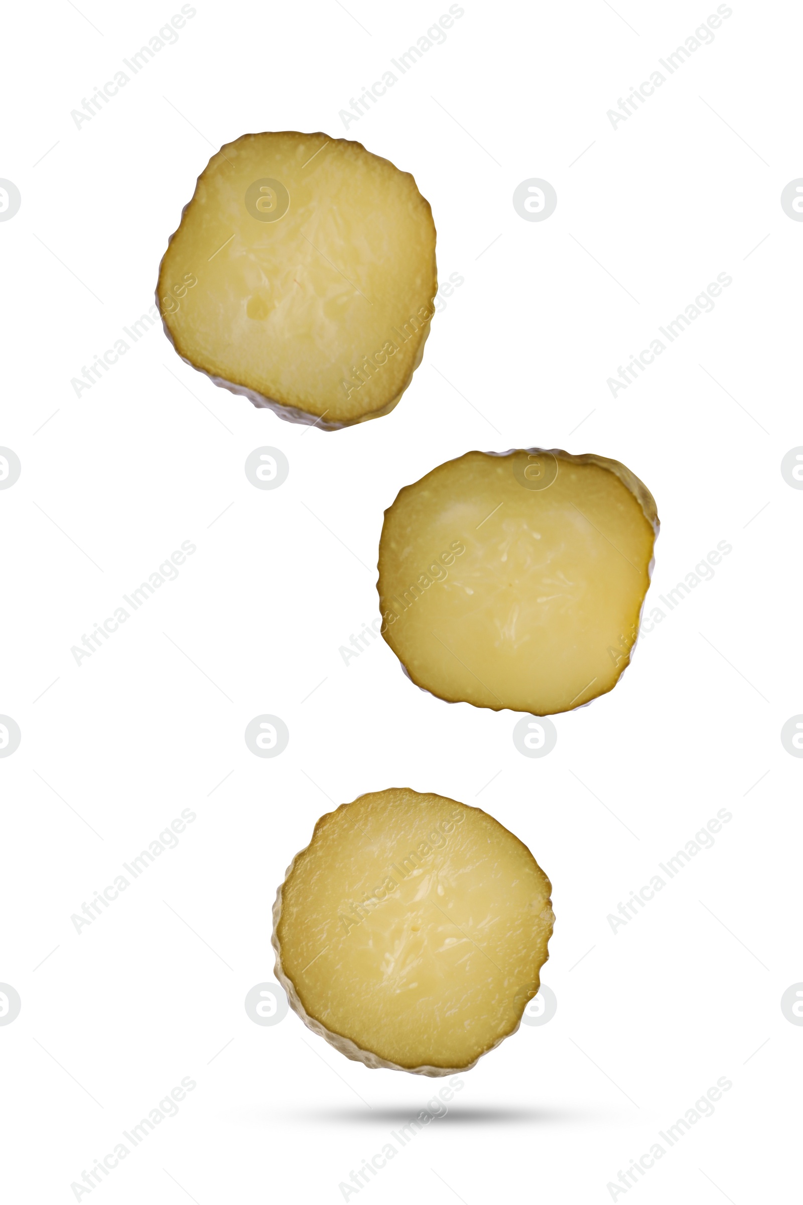 Image of Slices of tasty pickled cucumbers falling on white background