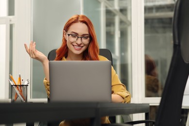 Photo of Happy woman having online meeting on laptop at desk in office