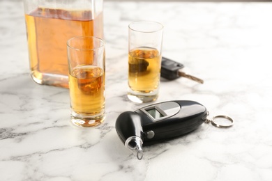 Photo of Modern breathalyzer and alcohol on white marble table