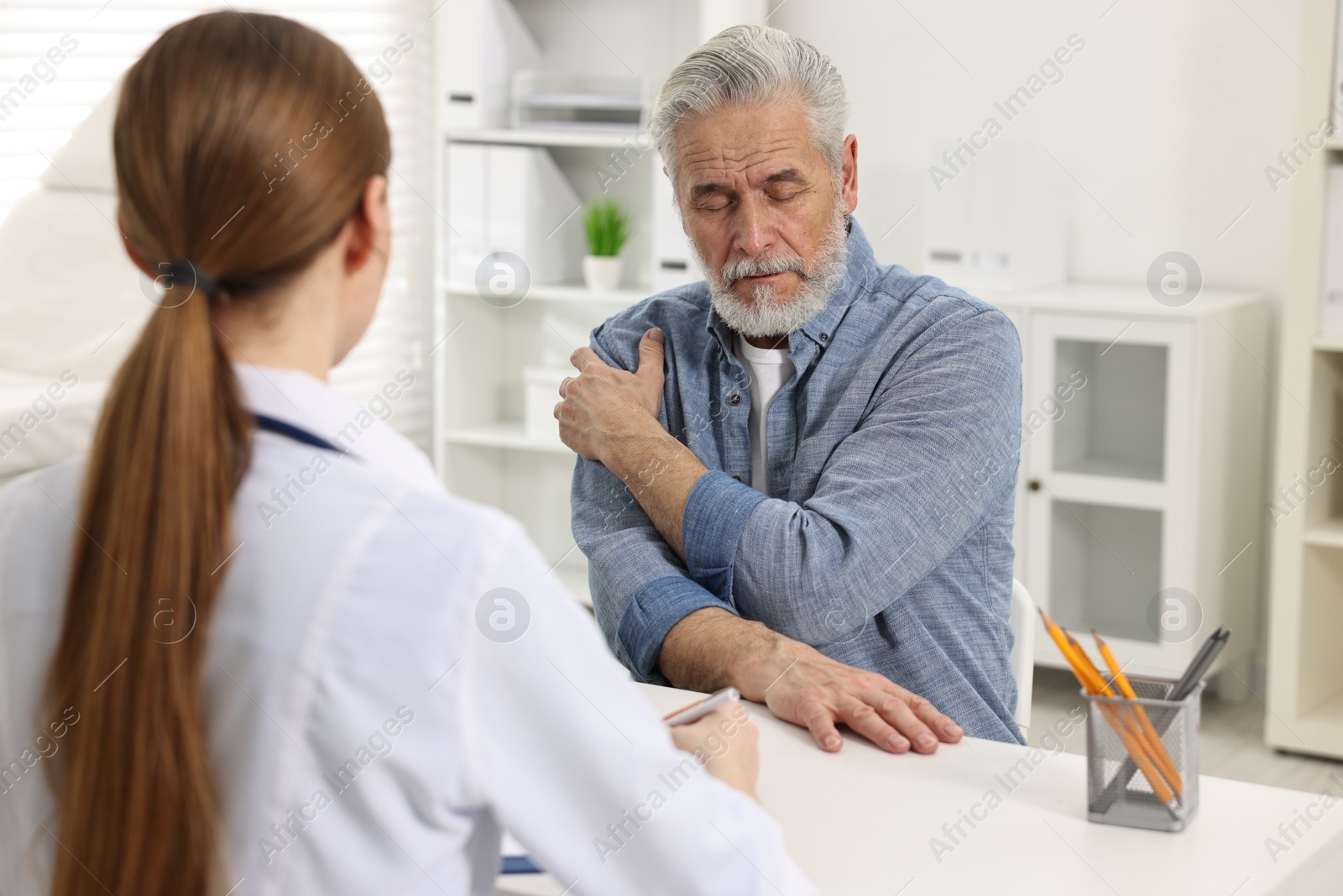 Photo of Arthritis symptoms. Doctor consulting patient with shoulder pain in hospital