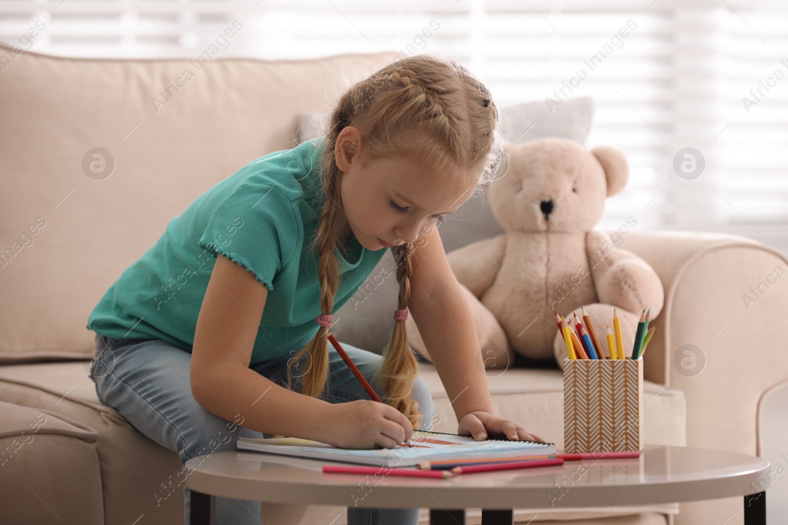 Photo of Little girl drawing in child psychotherapist's office