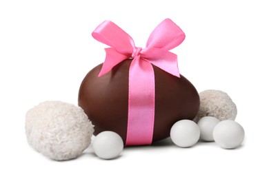 Photo of Sweet chocolate egg with pink bow and different candies isolated on white