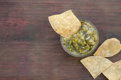 Tasty salsa sauce and tortilla chips on wooden table, flat lay. Space for text