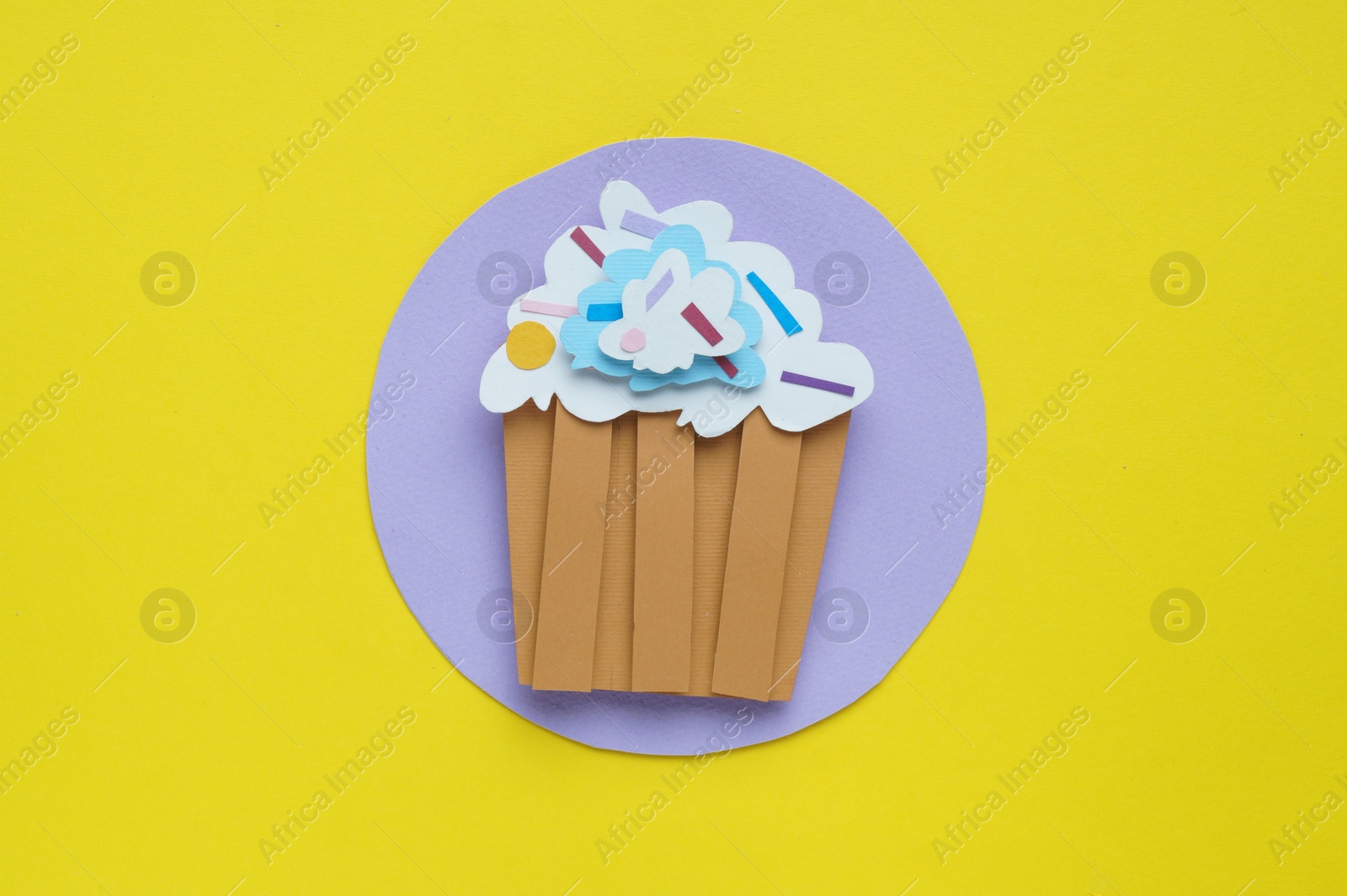 Photo of Birthday party. Paper cupcake on yellow background, top view