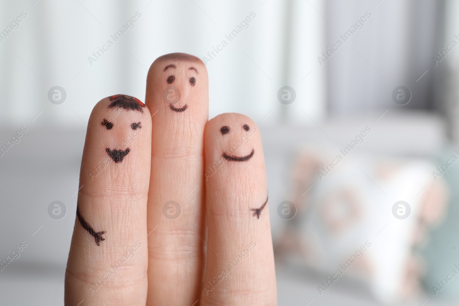 Photo of Three fingers with drawings of happy faces on blurred background