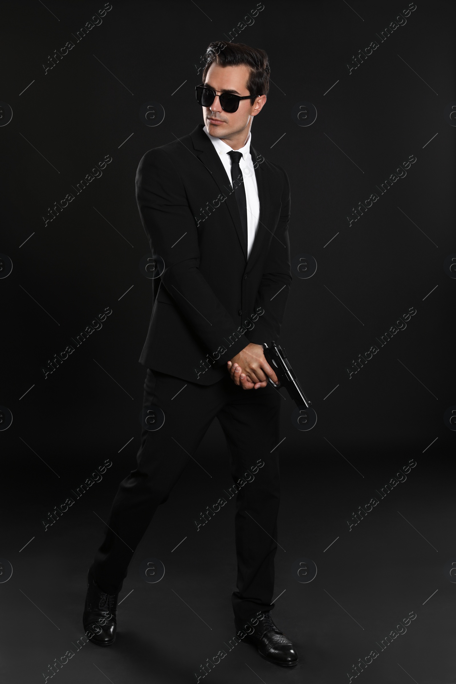 Photo of Male security guard in uniform with gun on dark background