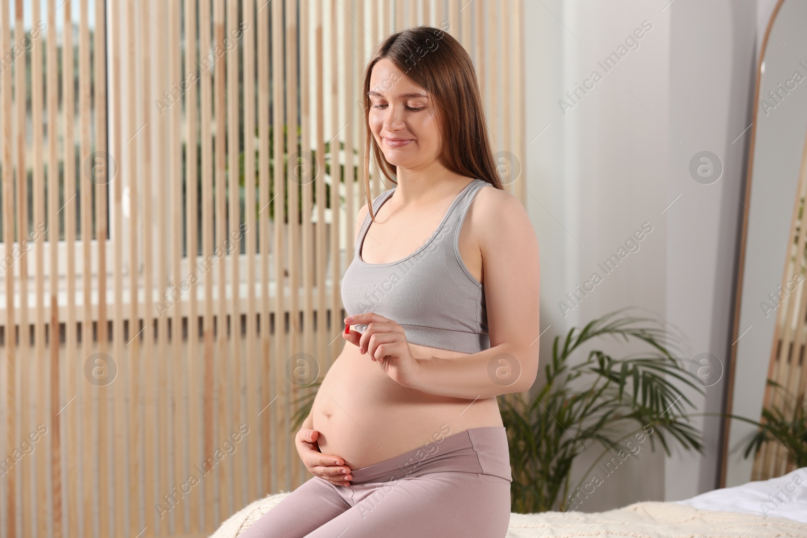 Photo of Beautiful pregnant woman taking pill at home