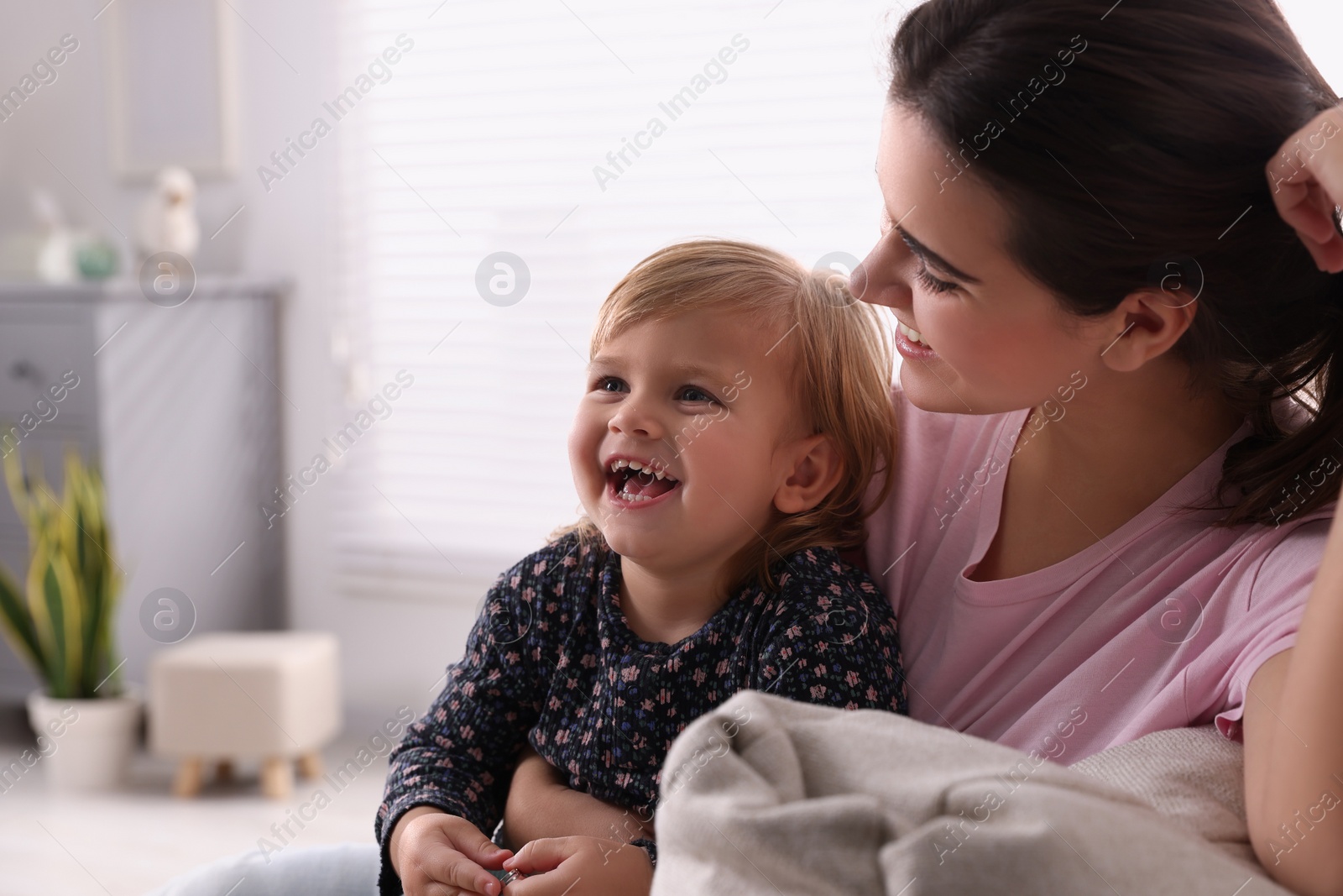 Photo of Mother with her cute little daughter at home, space for text