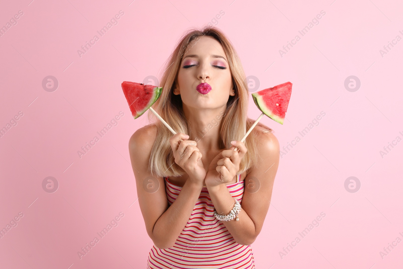 Photo of Pretty young woman with juicy watermelon on color background