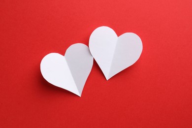 Photo of White paper hearts on red background, flat lay